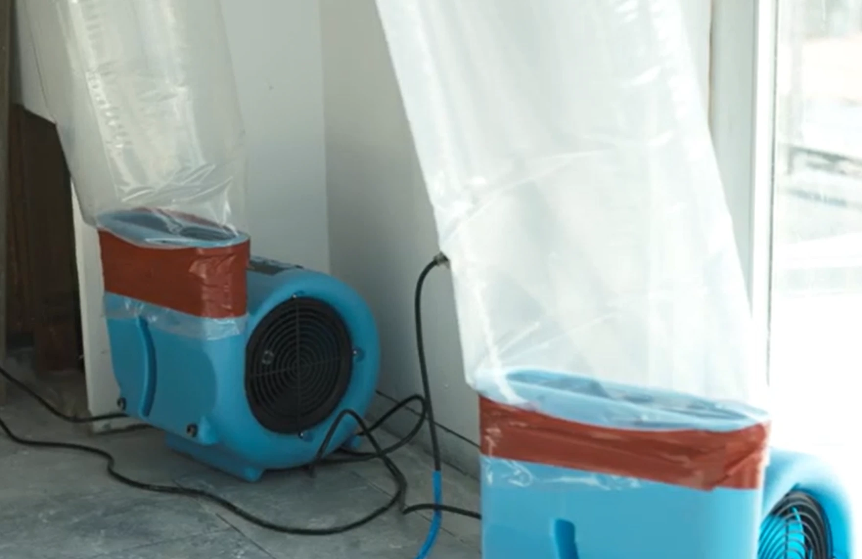 Air movers and plastic containment set up to dry a water damaged room