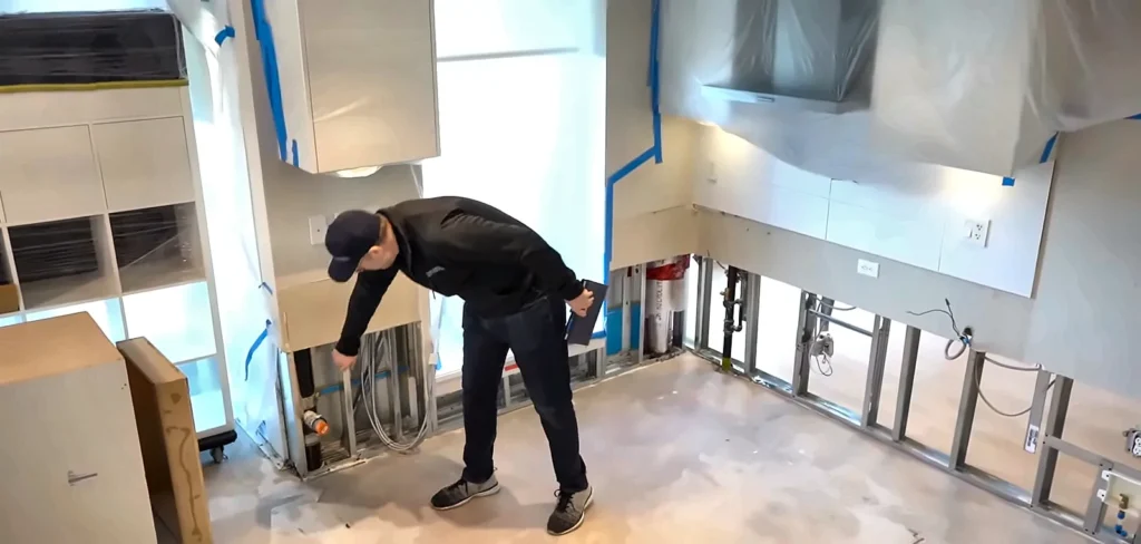 Fort Myers burst pipe cleanup: technician checking cabinet bases during burst pipe cleanup